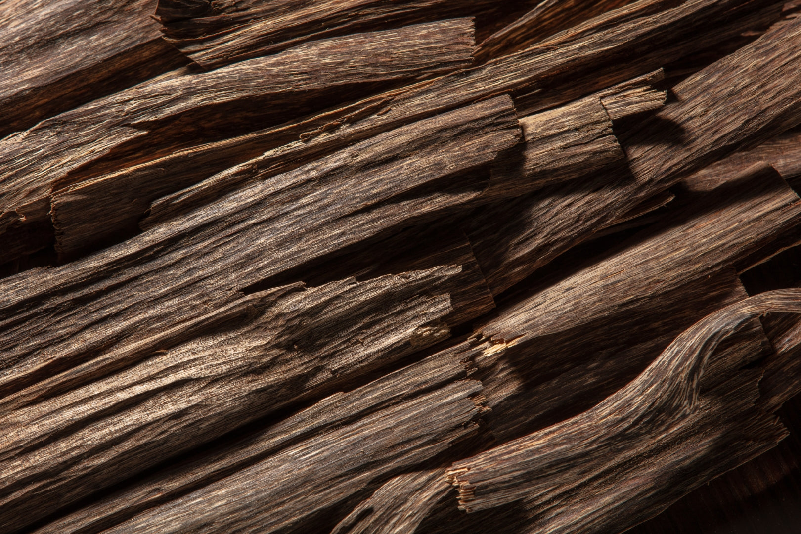  A pile of dark brown Agarwood chips with irregular shapes and sizes. 